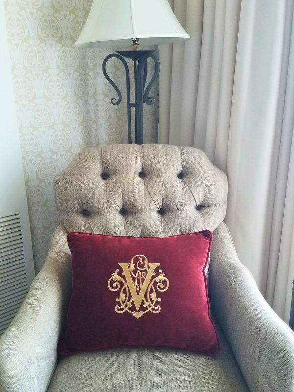 An armchair with a red pillow with the Vanderbilt emblem